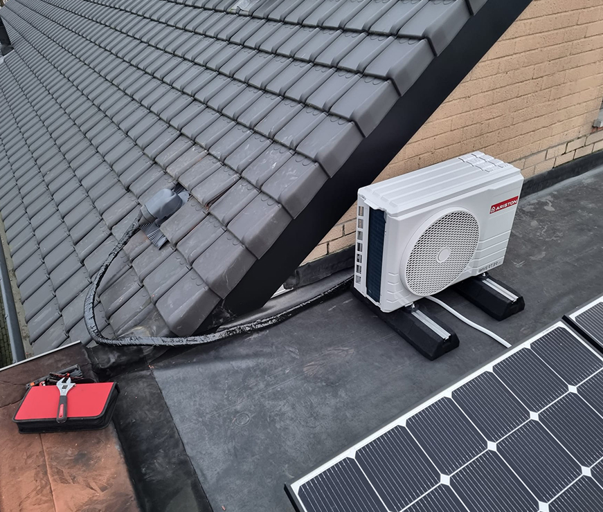 Buitenunit HVAC systeem met zonnepanelen op dak van woning in Wuustwezel
